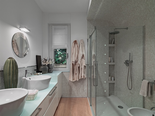 interior view of a modern bathroom with glass shower stall and wooden floor
